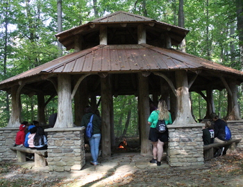 Students learning about fire teachings at a pavilion.