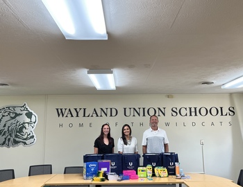 Superintendent with United Bank representative and school supplies