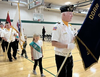 Veterans and a Girl Scout walking up front with flags