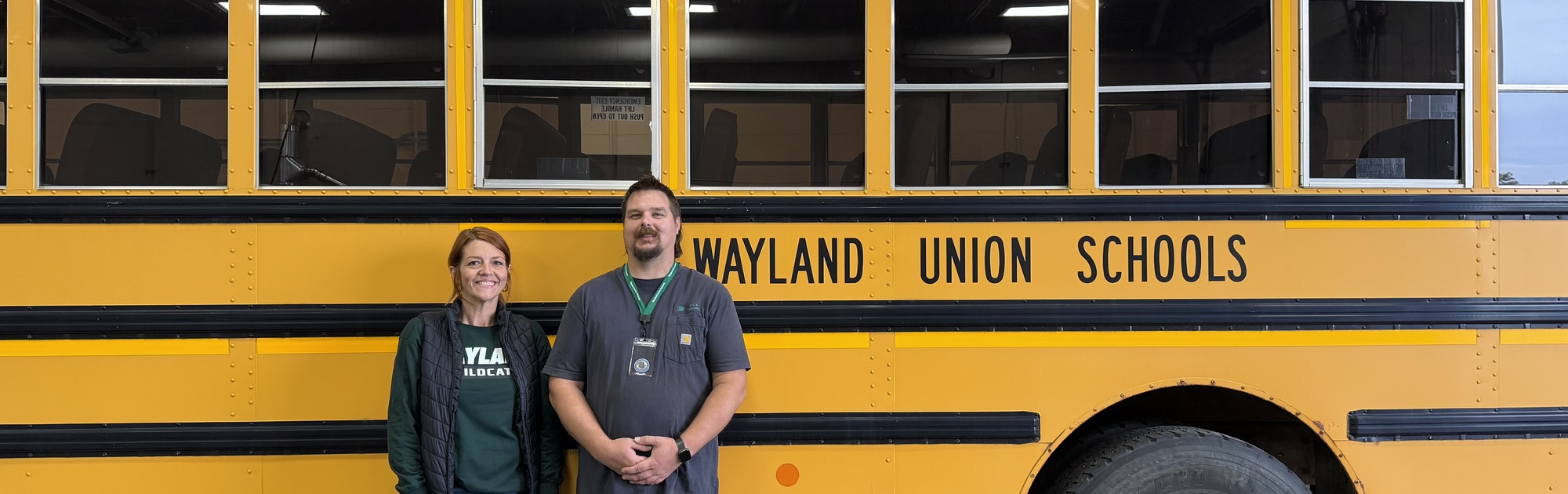 Karla Heckathron and John Syers standing in front of a bus